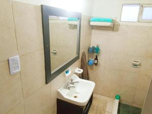 uma casa de banho com um lavatório e um espelho em La casita de Manu em Guaymallén