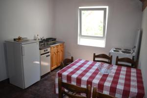 a kitchen with a table and a sink and a refrigerator at durmitor_nature in Žabljak