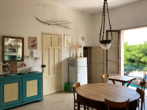 una cucina e una sala da pranzo con tavolo e frigorifero di Casa Adele a Sciacca