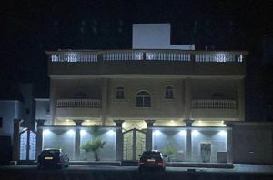 a building with two cars parked in front of it at night at التوفيق للوحدات السكنية T1 in Al Ahsa