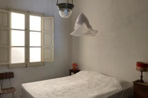 una camera bianca con un letto e una finestra di Casa Adele a Sciacca