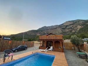 un patio trasero con piscina y una casa con montaña en Likya Garden Life, en Gâvurağılı