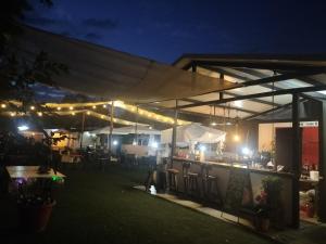 une terrasse avec un bar éclairé la nuit dans l'établissement Hostal New York City, à Sonseca