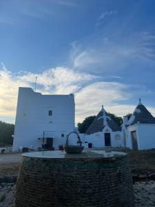 een wit gebouw met een mand ervoor bij Masseria Helianthus in Ceglie Messapica