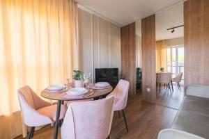 a dining room with a table and chairs and a television at ROSE Luxury Apartments in Lublin