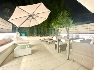 a patio with a table and an umbrella at Mottola Apartment in Tropea