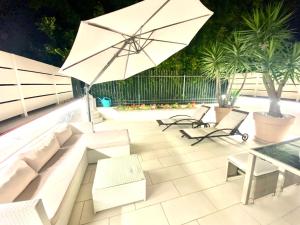 a patio with a couch and an umbrella at Mottola Apartment in Tropea