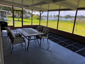 a table and chairs in a room with a view of a field at Lakeside retreat - 3 Bedroom, 2 Bathroom house by the lake in Lakeland