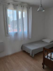 a white room with a bed and two windows at Charmant F3 lumineux proche plage et vue mer à Carqueiranne in Carqueiranne