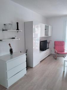 a living room with white furniture and a red chair at Charmant F3 lumineux proche plage et vue mer à Carqueiranne in Carqueiranne +4 photos
