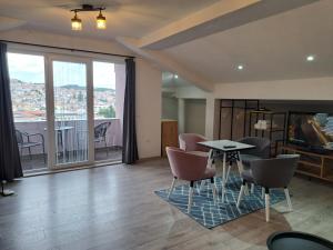 a living room with a table and chairs and a balcony at Papi Apartments in Kruševo