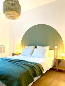 - une chambre avec un grand lit et une tête de lit verte dans l'établissement Le Condorcet. Charme et confort à Championnet, à Grenoble
