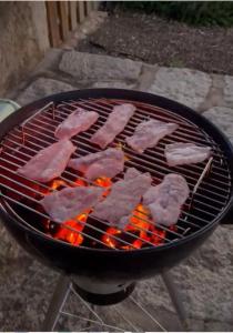 um monte de carne a cozinhar numa grelha em Herdade da Carapuça em Portalegre