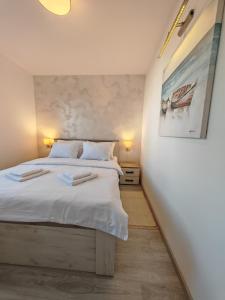 - une chambre avec un grand lit et une peinture murale dans l'établissement Apartman Holiday 1, à Veliko Gradište