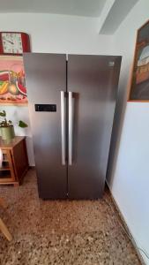a stainless steel refrigerator in the corner of a room at Ca La Luci in San Juan de Palamós