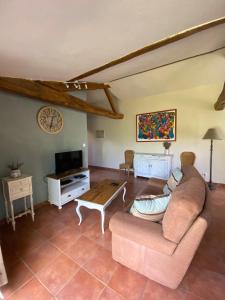 een woonkamer met een bank en een salontafel bij La Frapperie in La Pommeraie-sur-Sèvre