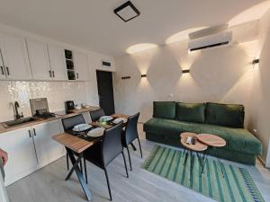 a living room with a green couch and a table at Apartman Holiday 1 - Srebrno jezero in Veliko Gradište