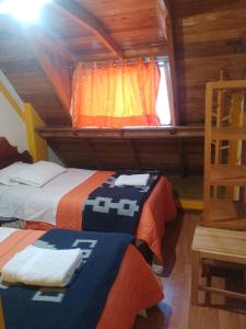 1 dormitorio con 2 camas en una cabaña de madera en hostal ollantaytambo apartments, en Ollantaytambo