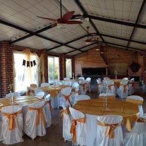 a banquet hall with tables and chairs and a fireplace at Finca Lo de Guarin in Vaqueros