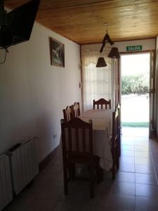 een eetkamer met een tafel en stoelen en een raam bij Finca Lo de Guarin in Vaqueros