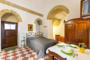 a bedroom with a bed and a table and chairs at L'Antico Palazzo in Vernole +15 photos