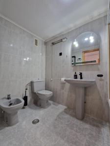a bathroom with a sink and a toilet and a mirror at Casa Bonita in San Pedro del Pinatar