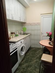 a kitchen with a washing machine and a table at Melson in Batumi