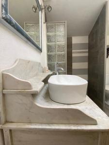 een badkamer met een witte wastafel en een spiegel bij La Frapperie in La Pommeraie-sur-Sèvre +41 foto's