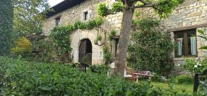a stone house with a tree in the yard at Casa Rural TTIPIAENEA Landetxea in Ariz