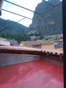 un bassin d'eau rouge avec des montagnes en arrière-plan dans l'établissement hostal ollantaytambo apartments, à Ollantaytambo