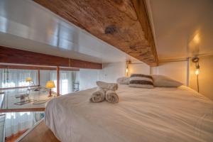 um quarto com uma grande cama branca com toalhas em Atypique - Hypercentre / Place aux Herbes em Grenoble