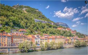 uma cidade numa colina junto a um rio em Atypique - Hypercentre / Place aux Herbes em Grenoble