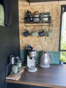 a kitchen counter with a coffee maker and cups at Horse Truck Tiny Home in Swords