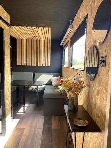 Habitación con sofá y mesa con flores en Horse Truck Tiny Home en Swords