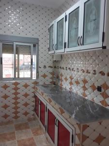 a kitchen with white cabinets and a counter top at Jbel Moussa Lodge in Rcham