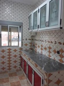 a kitchen with white cabinets and a counter top at Coopérative Village Jbel Moussa du Tourisme in Rcham