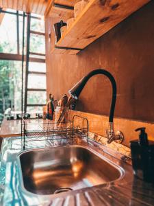 a kitchen sink with a faucet on a counter at Sítio Aroeira Cabanas in Sao Jorge