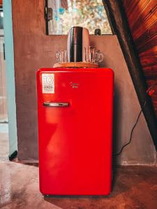 ein alter roter Kühlschrank neben einer Wand in der Unterkunft Sítio Aroeira Cabanas in Sao Jorge