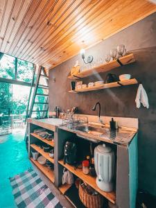 uma cozinha com um lavatório e uma bancada em Sítio Aroeira Cabanas em Sao Jorge