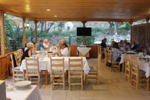 a group of people sitting at tables in a restaurant at Elly's Home in Mesudiye