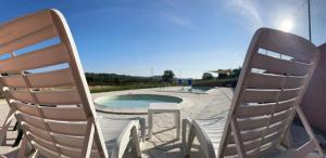 two chairs and a table and a swimming pool at La Filanda in Montalto delle Marche