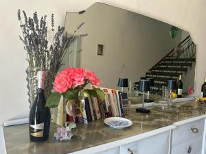 einen Tisch mit einer Flasche Wein und eine Vase mit Blumen in der Unterkunft La Filanda in Montalto delle Marche