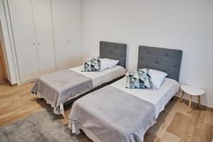 two beds sitting next to each other in a room at feel... Azores - apartments in Velas