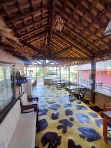 a large room with tables and chairs on a floor at Pousada Naturale in Trindade