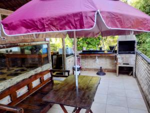 a large pink umbrella sitting on top of a table at Pousada Naturale in Trindade