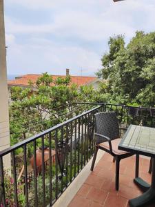 einen Balkon mit einem Tisch und einem Stuhl in der Unterkunft Casa Crara in Cala Gonone