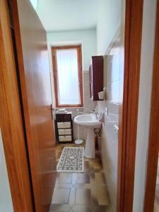 bagno con lavandino, servizi igienici e finestra di Casa Crara a Cala Gonone