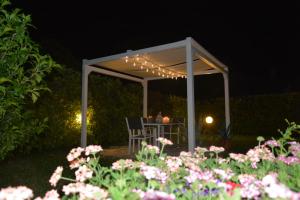 a white pergola with a table and chairs under it at Villa Luisa Design in Colle di Val d'Elsa