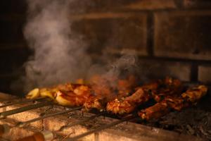Een hoop vlees koken op een grill bij Phoenix Villa in Zarritʼapʼ