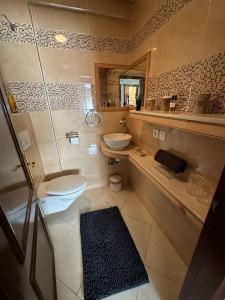 een badkamer met een toilet, een wastafel en een spiegel bij Bayti Appart in Agadir